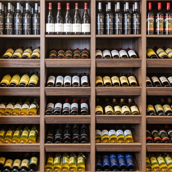 A large wooden wine rack filled with various bottles of red and white wine.