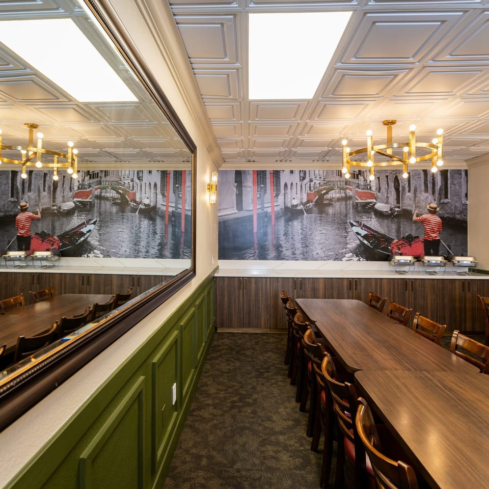 Di Leone's Italian Restaurant private dining room with long tables, chandeliers, and a Venice canal mural.