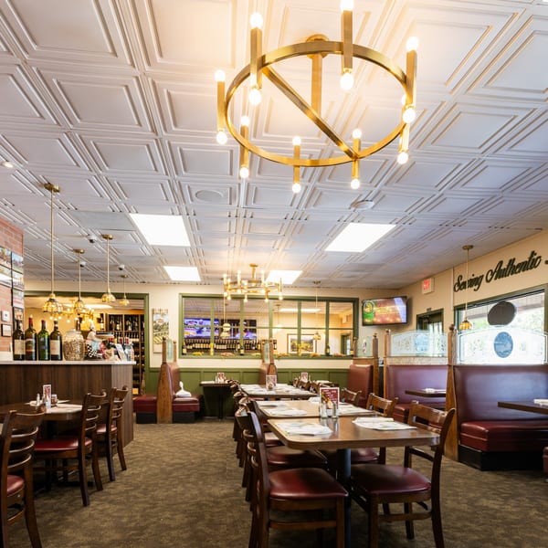 Interior of Di Leone's Italian Restaurant with tables, chairs, booths, and a bar area.